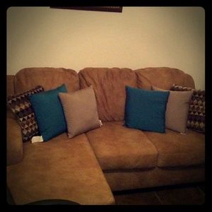 A chase couxh and a desk chair a square ottoman